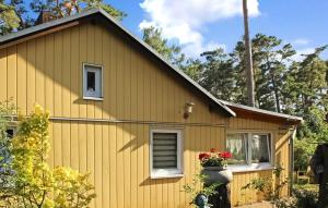 uma casa amarela com um vaso de flores ao lado em Pet Friendly Home In Lubmin seebad With Kitchen em Lubmin