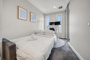 Tranquil Apartment in Green, Well Connected Suburb في Lyons: غرفة نوم بيضاء مع سرير كبير مع شراشف بيضاء