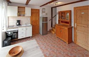 a kitchen with wooden cabinets and a table in it at 2 Bedroom Cozy Apartment In Sdmritz in Vipperow