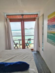 a bedroom with a bed and a view of the ocean at Casa Bajo Congo in Cacique