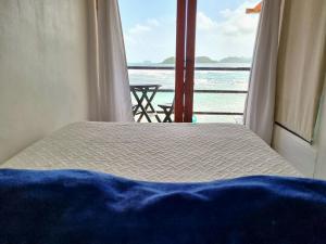 a bed in a room with a view of the ocean at Casa Bajo Congo in Cacique