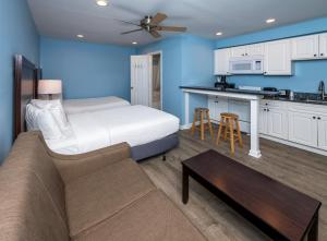 a living room with a bed and a kitchen at Commander Beach House Hotel in Ocean City