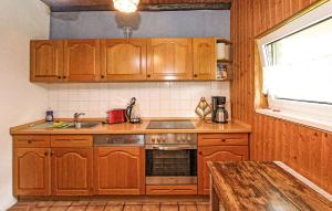 Una cocina con gabinetes de madera y un fregadero. en Ferienhaus Fürstenhagen, en Fürstenhagen