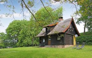 una pequeña casa con techo de paja en un campo en Nice Home In Frstenhagen With Lake View, en Fürstenhagen