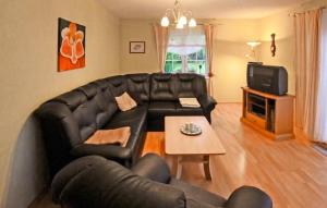 uma sala de estar com um sofá de couro preto e uma mesa em 2 Bedroom Awesome Apartment In Zirtow em Mirow