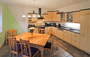uma cozinha com uma mesa de madeira e algumas cadeiras em 2 Bedroom Awesome Apartment In Zirtow em Mirow