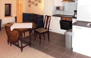 - une cuisine avec une table, deux chaises et un canapé dans l'établissement 1 Bedroom Nice Apartment In Kuchelmi, à Kuchelmiß
