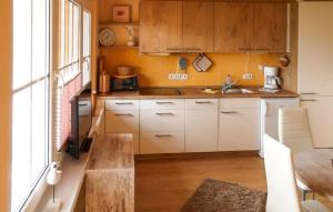 eine Küche mit weißen Schränken und einem Holztisch in der Unterkunft Beautiful Home In Mnkebude With Kitchen in Mönkebude