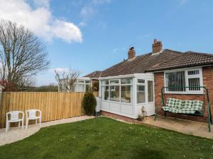 een huis met een hek en een bank in de tuin bij Seaside Cottage in Scarborough
