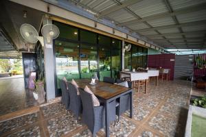 a dining room with a wooden table and chairs at Khong Chiam Orchid Riverside Resort in Khong Chiam