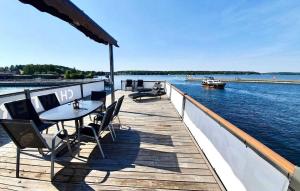 a dock with tables and chairs and a boat on the water at 3 Bedroom Lovely Ship In Waren mritz in Waren