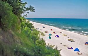 a beach with umbrellas and people on the sand at Stunning Home In Klpinsee-usedom With Kitchen in Kolpinsee