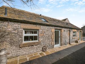 an old stone building with a window and a door at The Loft-uk45061 in Tideswell