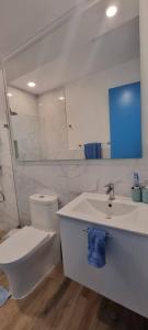a white bathroom with a toilet and a sink at SantoriniRD in Punta Cana