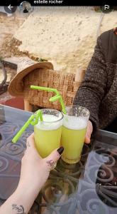 uma pessoa que segura duas bebidas numa mesa em hostel Dar belghiti em Fez