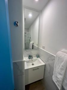 a white bathroom with a sink and a mirror at SantoriniRD in Punta Cana