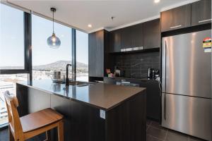 a kitchen with a stainless steel refrigerator and a counter at Lovely Sunny 2-bedroom Apartment with Pool and Gym in Phillip