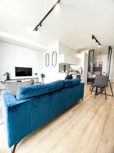 ein blaues Sofa im Wohnzimmer mit Küche in der Unterkunft ERL Ellipse Waterfall. in Midrand