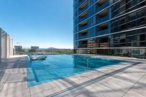 a swimming pool on the side of a building at Lovely Sunny 2-bedroom Apartment with Pool and Gym in Phillip