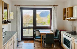 une cuisine avec une table et une grande fenêtre dans l'établissement Nice Home In Rbel-mritz With Kitchen, à Röbel