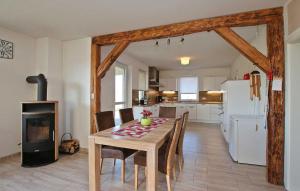 a kitchen and dining room with a table and a refrigerator at Nice Home In Grnow Ot Ollendorf With Kitchen in Blankensee