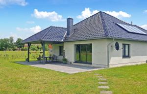 a small white house with a patio in a field at Nice Home In Grnow Ot Ollendorf With Kitchen in Blankensee