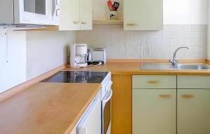 a kitchen with white cabinets and a sink at 2 Bedroom Lovely Apartment In Ostseebad Breege Ot Ju in Drewoldke