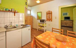a kitchen with a table and a sink and a table and chairs at 1 Bedroom Awesome Home In Rheinsberg Ot Zechline in Scharfenberg