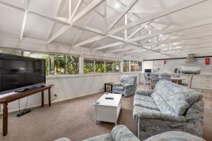 a living room with couches and a flat screen tv at Bon Villas B&B Bonville in Coffs Harbour