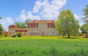 a large building with a tree in the middle of a field at 1 Bedroom Nice Home In Kummerow in Kummerow