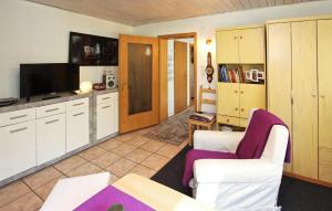 salon z 2 białymi krzesłami i telewizorem w obiekcie Amazing Home In Rheinsberg Ot Kagar With Kitchen w mieście Kagar