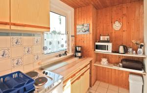 cocina con armarios de madera y horno con fogones en 1 Bedroom Lovely Home In Garz Auf Rgen, en Garz