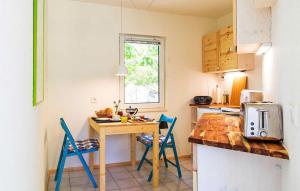 a kitchen with a wooden table and blue chairs at Lovely Apartment In Rheinsberg Ot Kagar With Kitchen in Kagar