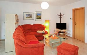 a living room with a red couch and a table at Lovely Apartment In Walow Ot Strietfeld With Lake View in Strietfeld