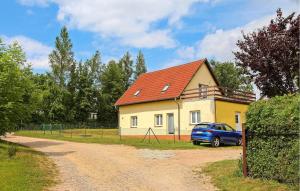 a house with a car parked next to a dirt road at Lovely Apartment In Walow Ot Strietfeld With Lake View in Strietfeld
