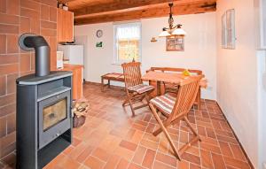 a kitchen and dining room with a wood stove at 1 Bedroom Cozy Home In Jabel Ot Loppin in Loppin