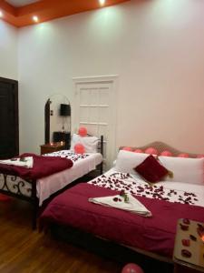 a bedroom with two beds with red and white sheets at Meramees Hotel in Cairo