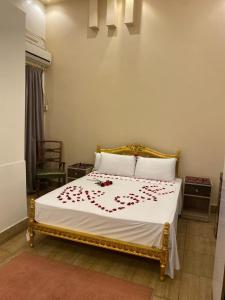 ein Schlafzimmer mit einem Bett mit roten Blumen darauf in der Unterkunft Meramees Hotel in Kairo