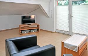 een woonkamer met een stoel en een televisie bij 1 Bedroom Beautiful Apartment In Grnow in Blankensee