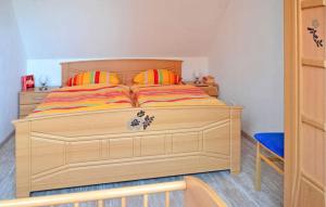 a bedroom with a wooden bed with two pillows at 2 Bedroom Lovely Apartment In Feldberger Seenlandsch in Conow