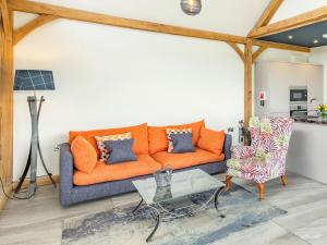 uma sala de estar com um sofá laranja e uma mesa em Oak View em Highgate