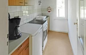 a white kitchen with a sink and a stove at 2 Bedroom Beautiful Home In Boitzenburger Land in Rosenow