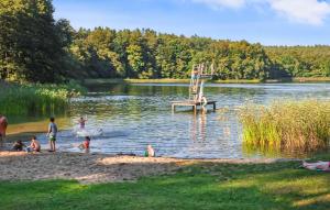 a group of children playing in a lake at 2 Bedroom Beautiful Home In Boitzenburger Land in Rosenow