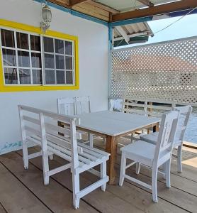 einen weißen Tisch und Stühle auf einer Terrasse in der Unterkunft Paraíso frente al Mar. in Carenero