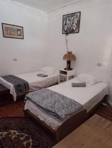 1 dormitorio con 2 camas y mesa con lámpara en Paraíso frente al Mar., en Carenero