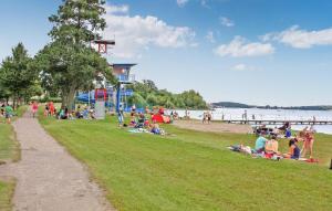 a group of people sitting on the grass at the beach at Nice Home In Waren mritz With Kitchen in Warenshof