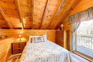 een slaapkamer met een bed en een raam in een hut bij Rustic Woods in Hazelhurst