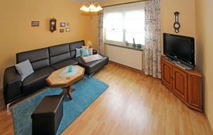 uma sala de estar com um sofá preto e uma televisão em Beautiful Home In Wolgast-mahlzow With Wifi em Wolgasterfähre
