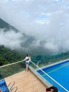 una mujer parada en una terraza junto a una piscina en Hương Trà Villa - Hotel Tam Đảo, en Tam Ðảo
