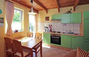 cocina con armarios verdes y mesa de madera en 2 Bedroom Awesome Home In Rheinsberg Ot Zechline, en Scharfenberg